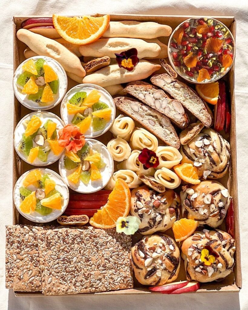 plateau brunch avec babka chocolat noisettes, fromage, labneh sucré, navettes à la fleur d'oranger, croquants aux amandes, crackers et fruits de saison