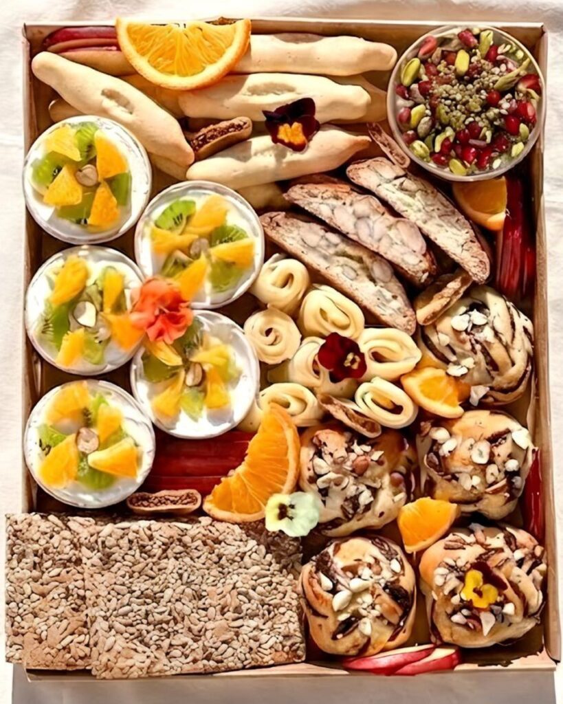 plateau brunch avec babka chocolat noisettes, fromage, labneh sucré, navettes à la fleur d'oranger, croquants aux amandes, crackers et fruits de saison