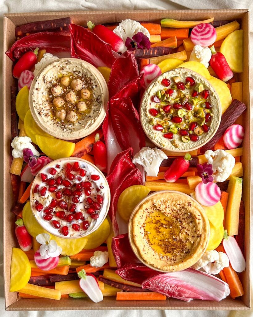 plateau fait maison pour un apéro avec crème de feta à la pistahce, labneh, houlous de lentilles corails, houmous et légumes de saison