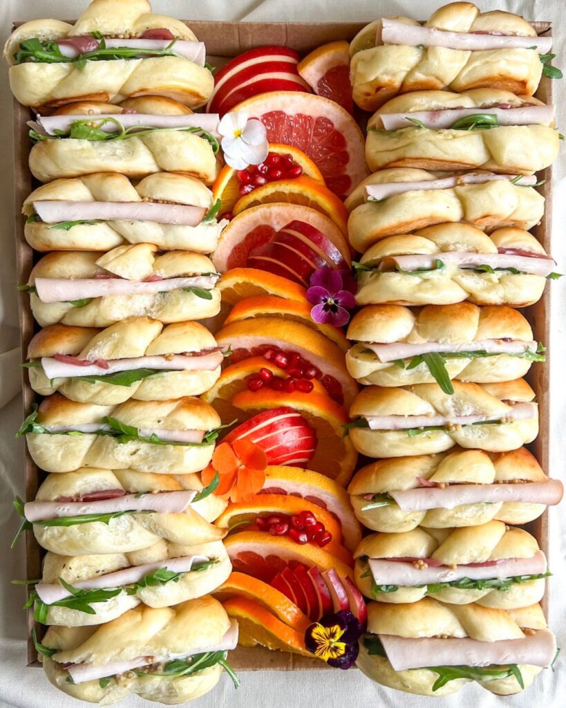 Mini hallot composées maison : mini hallot maison, chiffonnade de dinde, roquette, mayonnaise à l’estragon maison, pickles d’oignons rouges & de graines de moutarde maison Assortiment de fruits frais BIO de saison Fleurs fraîches comestibles